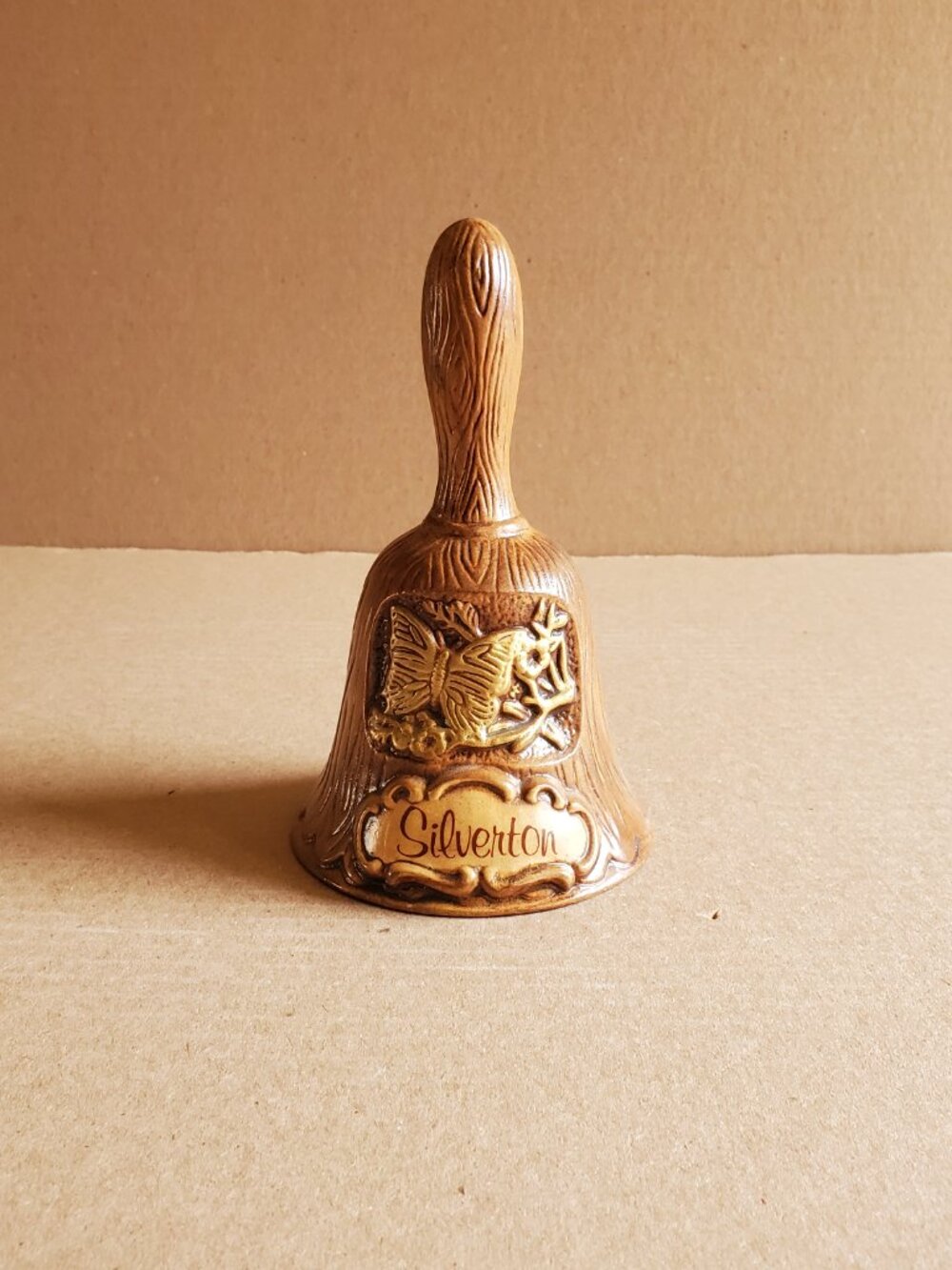Treasure Craft Bell "Silverton" Brown Wood Grain Ceramic Butterfly Emblem